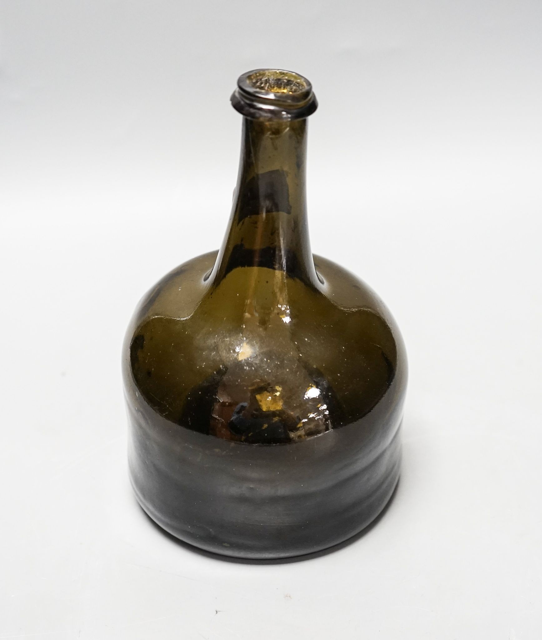 An English dark green glass ‘mallet’ wine bottle, c.1740, 21cm high